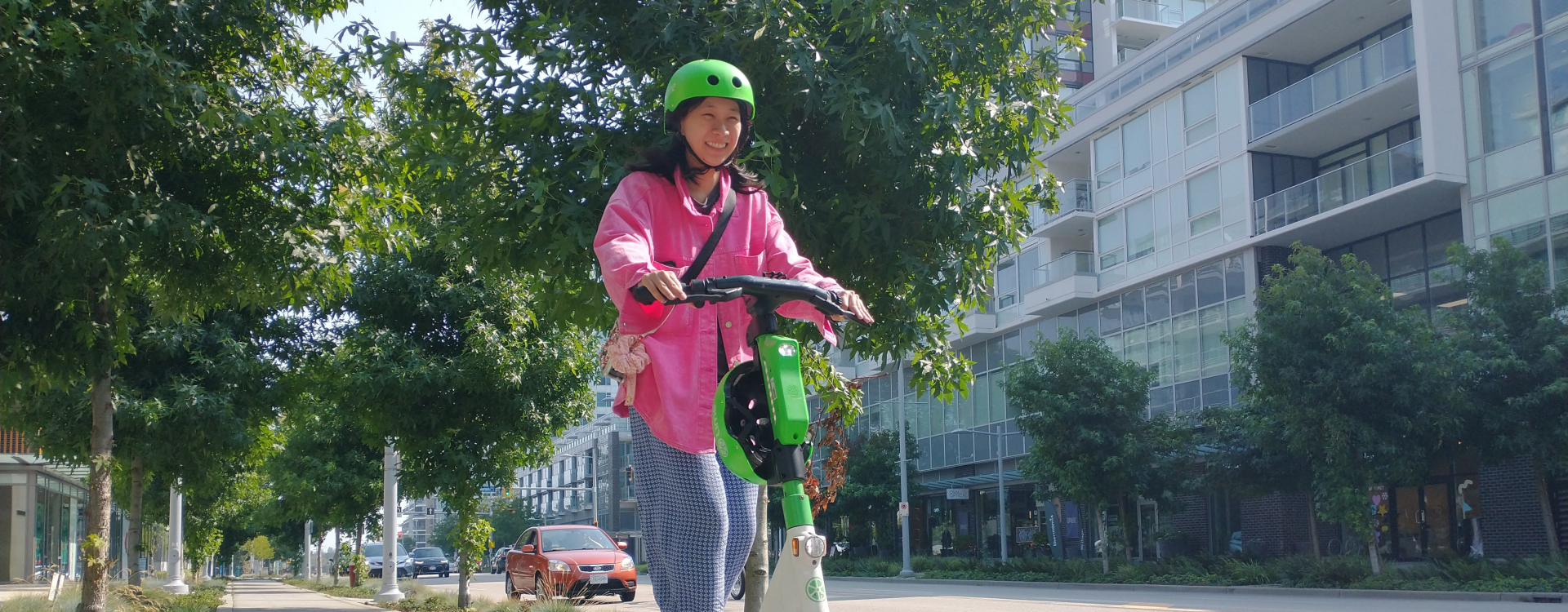 A woman rides a scooter.