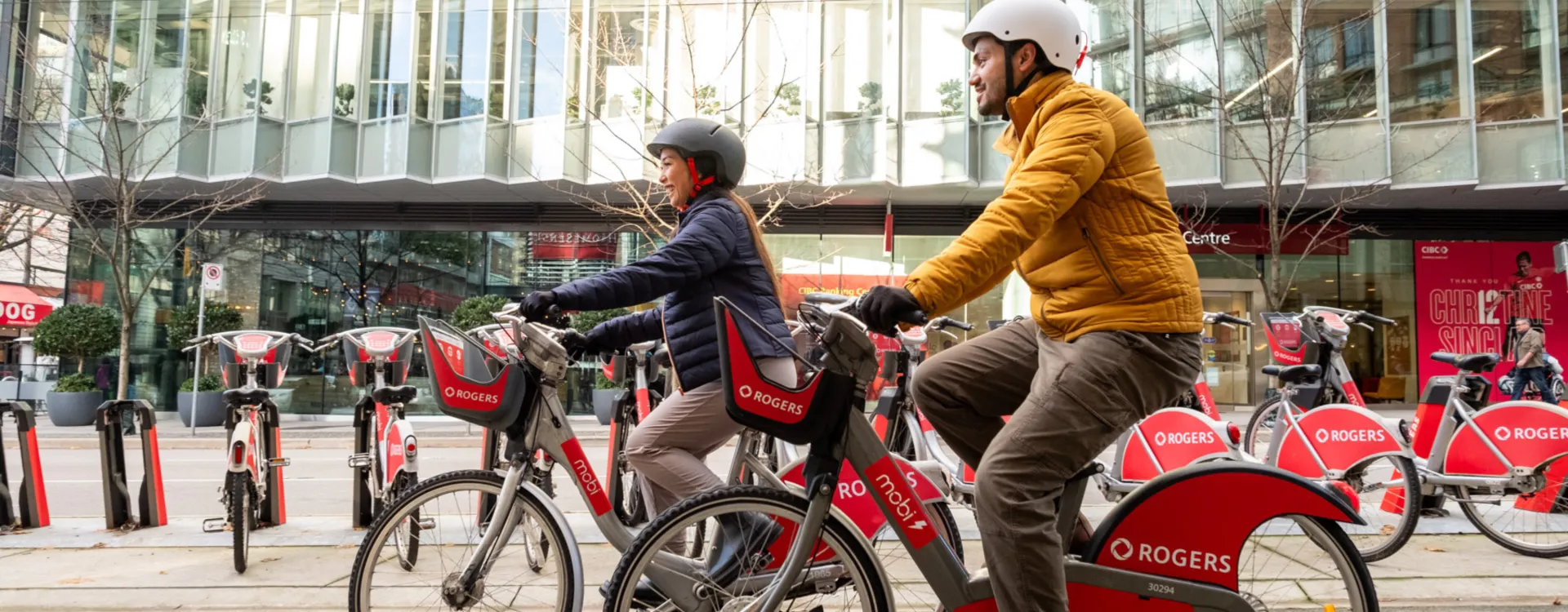 Two people ride Mobi by Rogers bikes.